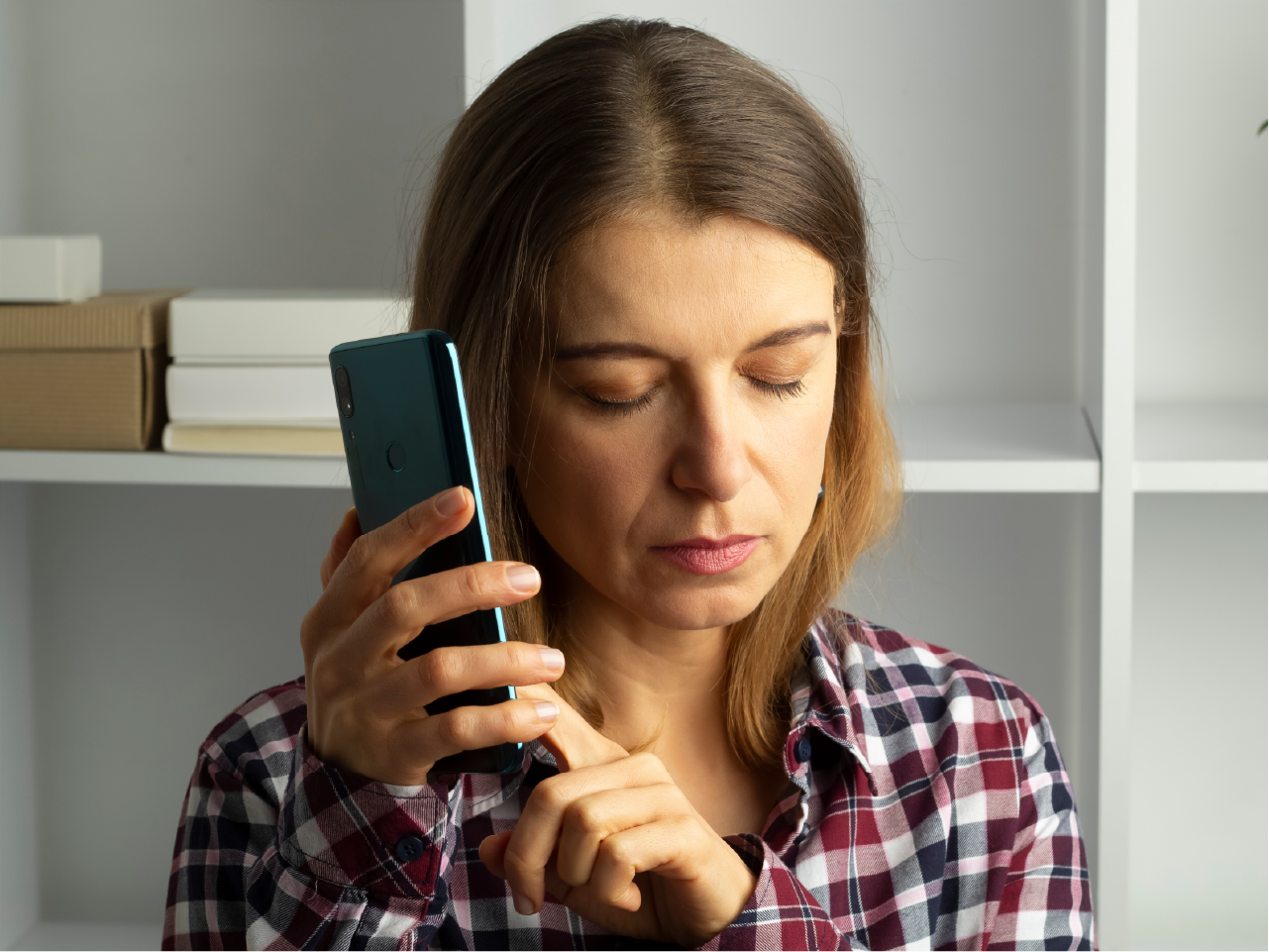A woman who is blind listens as she navigates her phone using a screen reader.