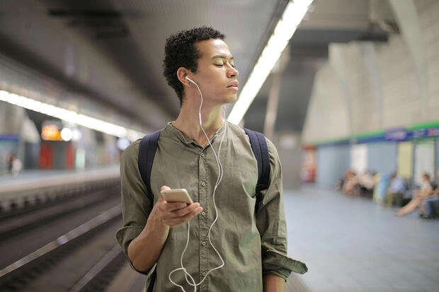 A young man who is blind navigates his phone with a screen reader.