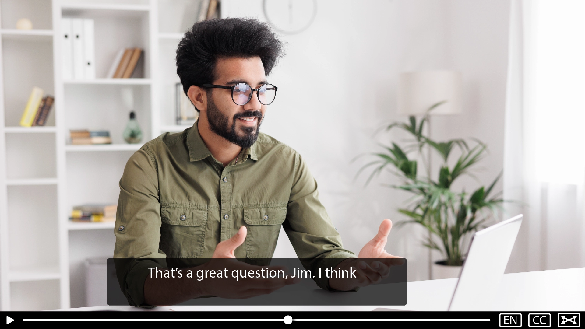 A caption over a video of one man speaking. The caption is short and breaks mid sentence.