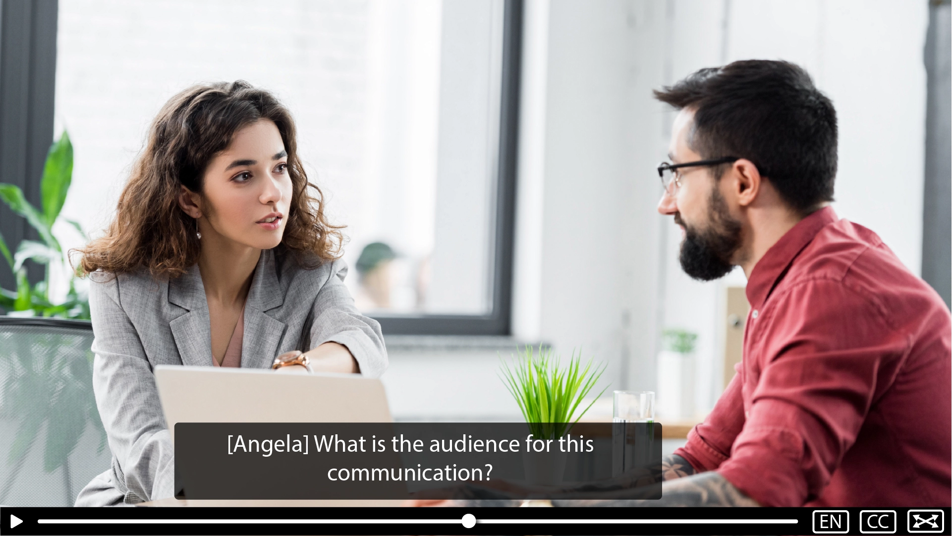 A caption over a video with a speaker identification label.